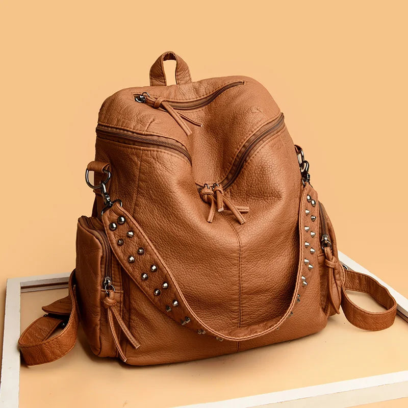 Sac à dos en cuir fauve avec rivets et fermeture à cordon.