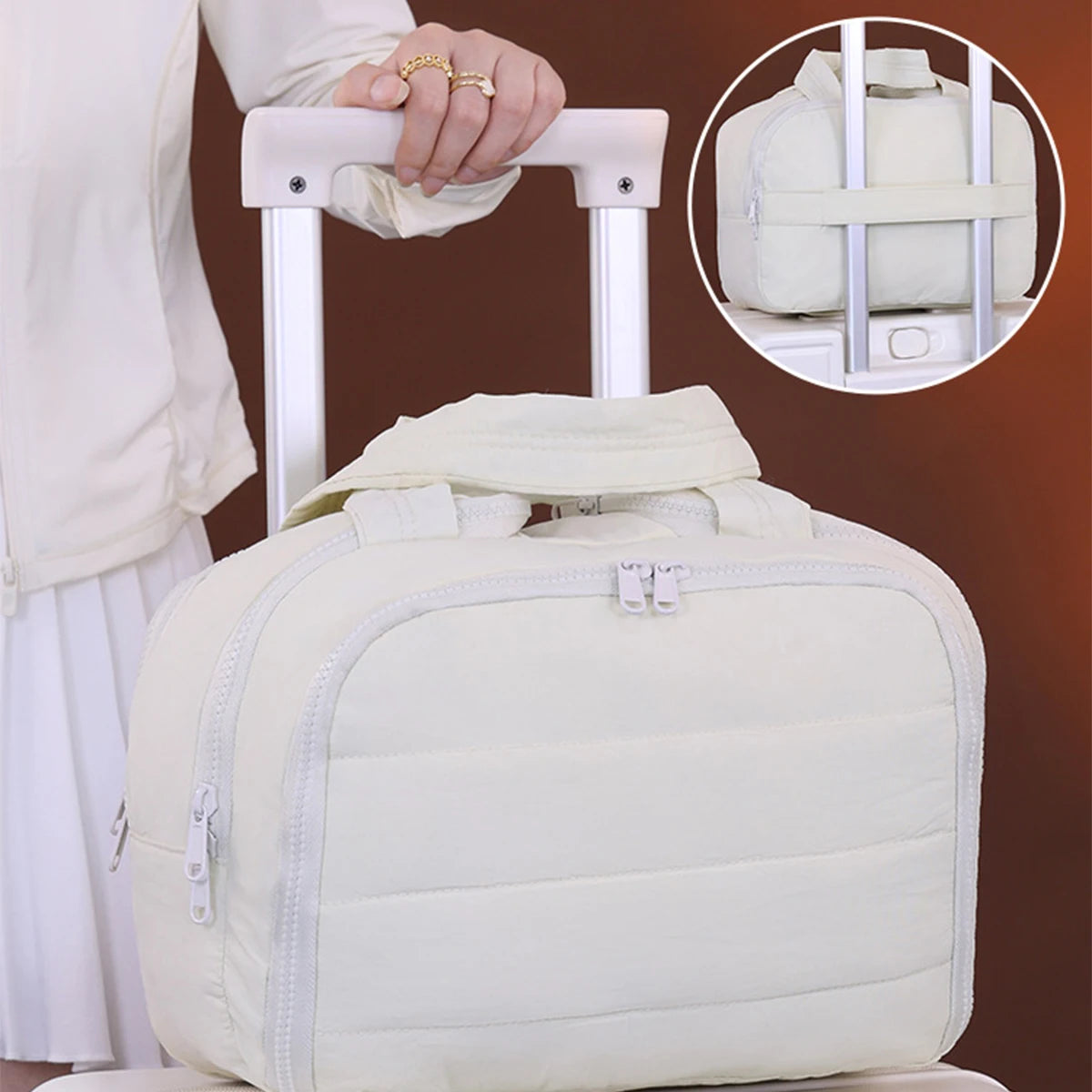 A cream-colored portable side-zip cosmetic organizer bag is shown being held by a hand on a white stand.