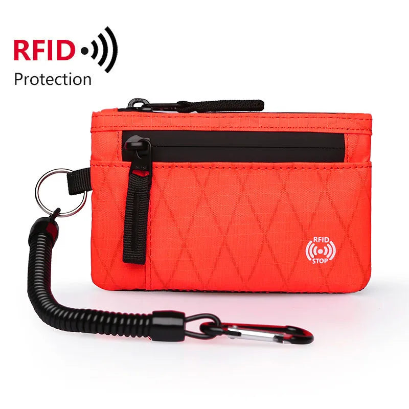 Orange RFID blocking travel wallet with a black carabiner attached.