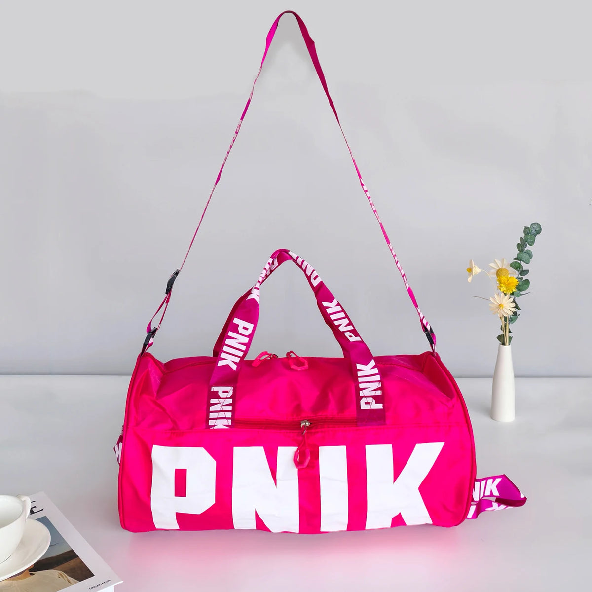 A bright pink Nike backpack with white lettering is displayed against a light gray background.