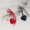 A collection of heart-shaped keychains and charms in red, silver, black, and white leather and metal.