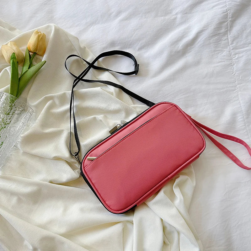 A pink multi-functional passport and document organizer bag lying on a white sheet with yellow tulips.