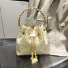 A gold chain clutch bag heavily embellished with sparkling crystals and beads, displayed against a neutral background.