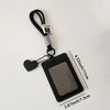 A black leather credit card and ID holder attached to a keychain with a heart charm.