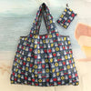A blue and white patterned Miffy folding shopping bag with a matching fabric pouch is displayed on a light surface.
