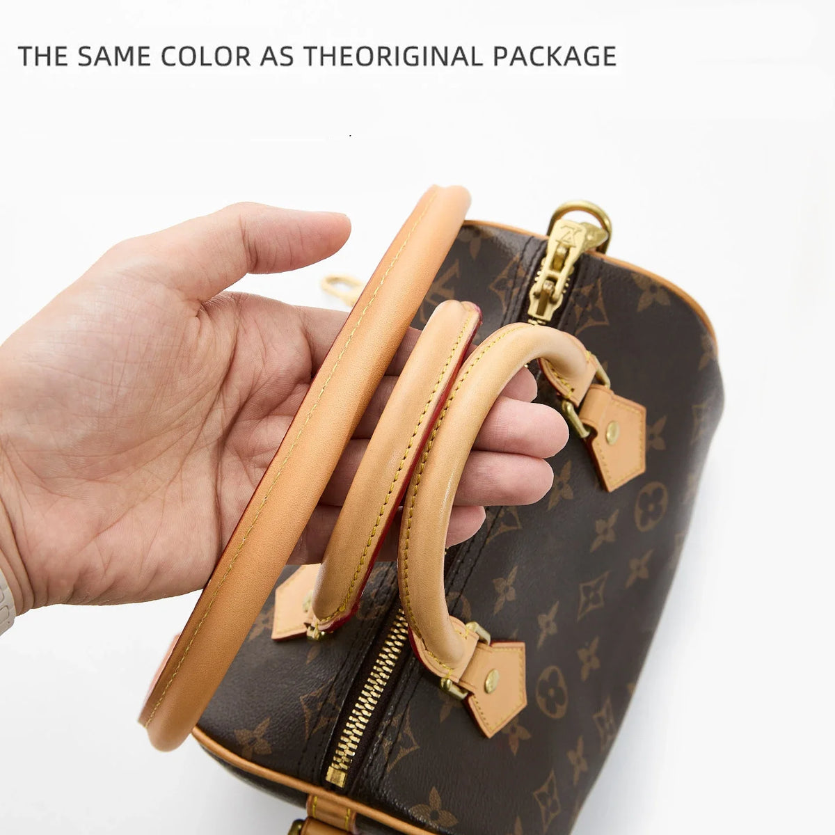 A hand holds a brown synthetic leather bag with gold hardware and a matching strap.