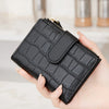 A hand holds a black PU leather bifold wallet with a zipper closure.