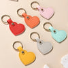 A collection of colorful leather heart keychains in pink, orange, red, mint green, and yellow.