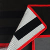 A triangular insulated pizza delivery bag with a silver foil lining and red trim on a black background.