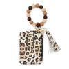 A leopard print faux leather card holder and tassel keychain with a beaded bracelet.