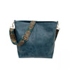 A dark blue leather crossbody hobo bag with a patterned strap.