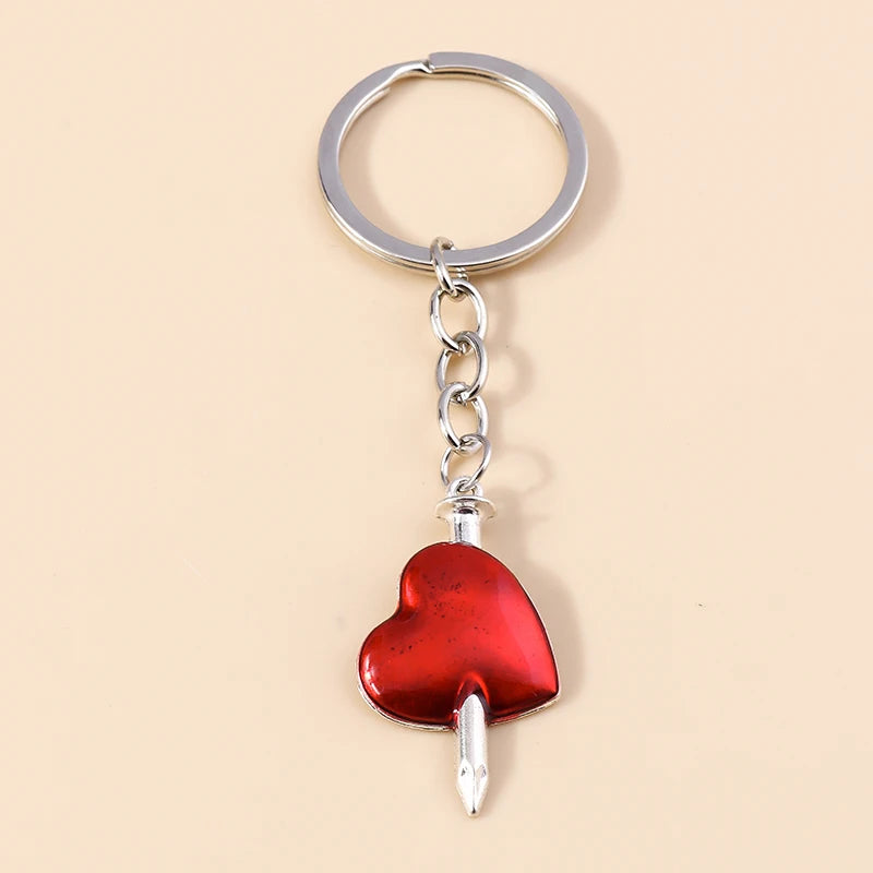 Silver chain keychain featuring a red heart pendant with a sun eye design.