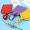 Three purple, red, and yellow PU leather luggage tags with leather straps are displayed on a light blue background.