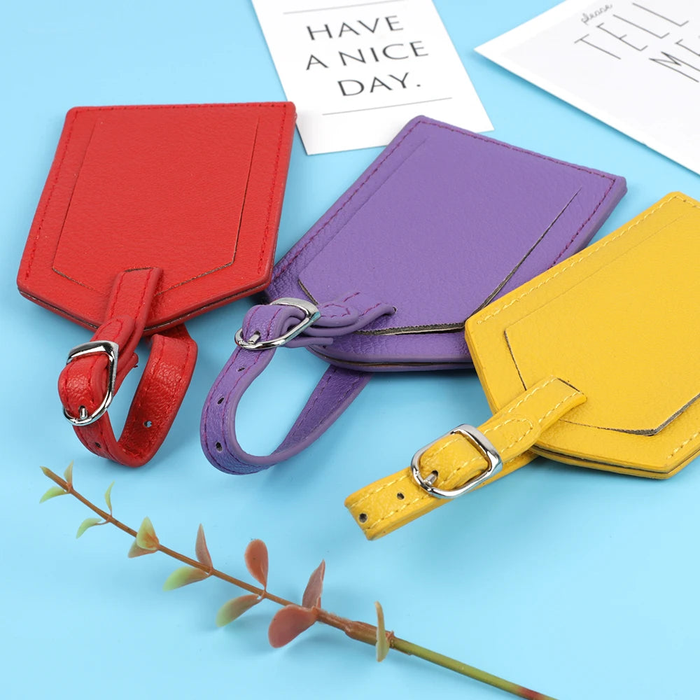 Three purple, red, and yellow PU leather luggage tags with leather straps are displayed on a light blue background.