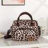 A brown and black leopard print thermal storage bag with leather straps resting on a white surface.