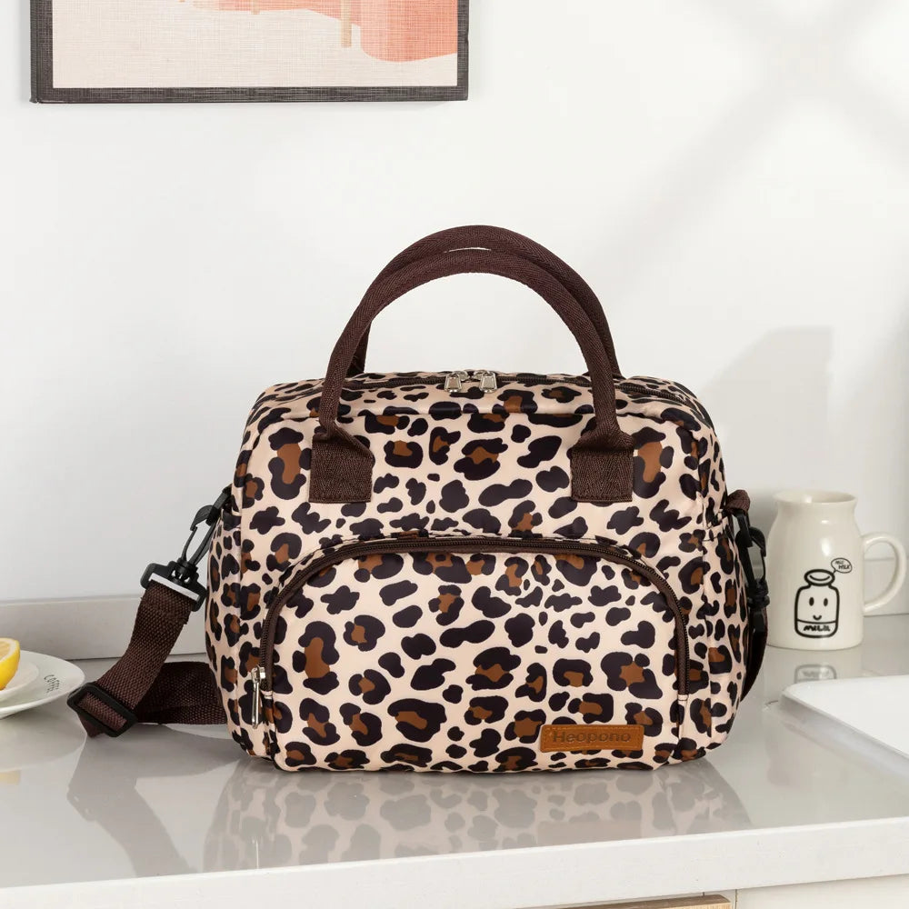A brown and black leopard print thermal storage bag with leather straps resting on a white surface.