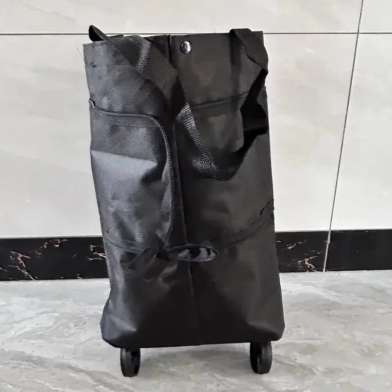 A black foldable lightweight shopping cart with wheels standing on a gray floor.