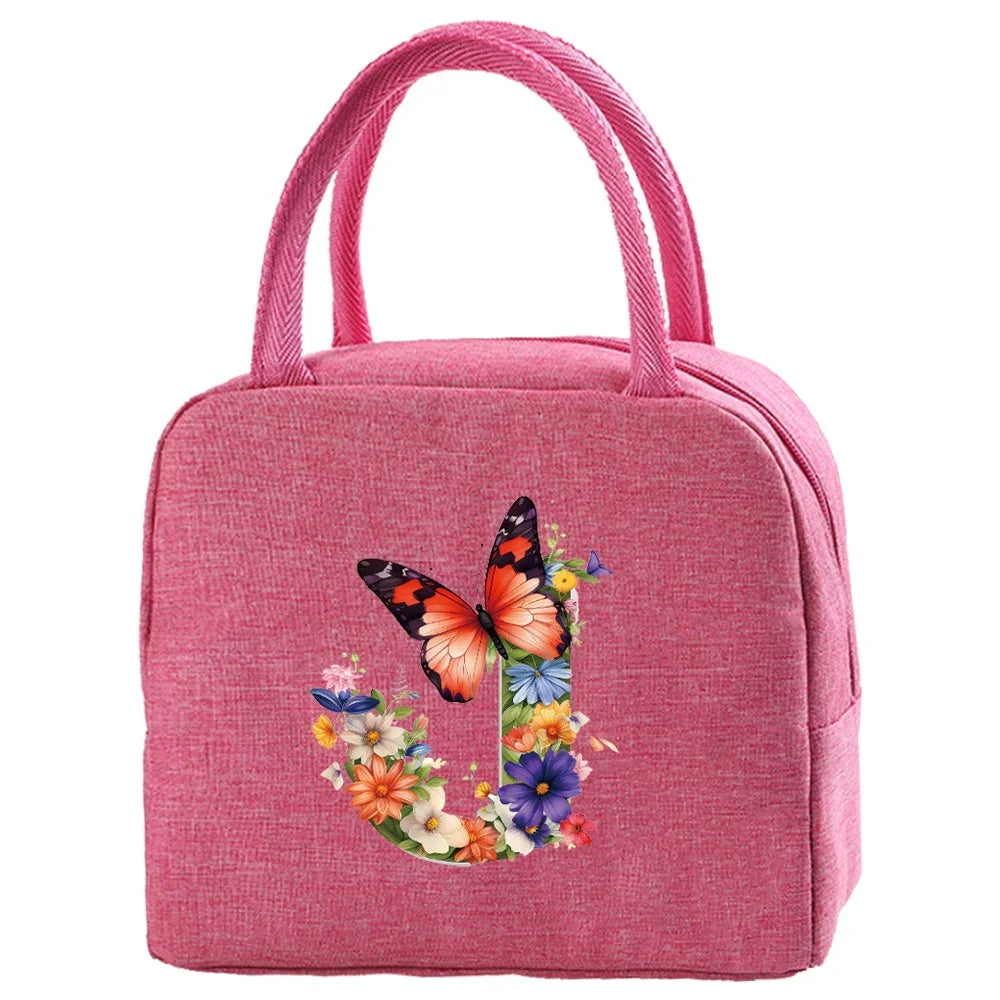 A pink insulated canvas lunch bag with pink fabric handles and a floral butterfly design.