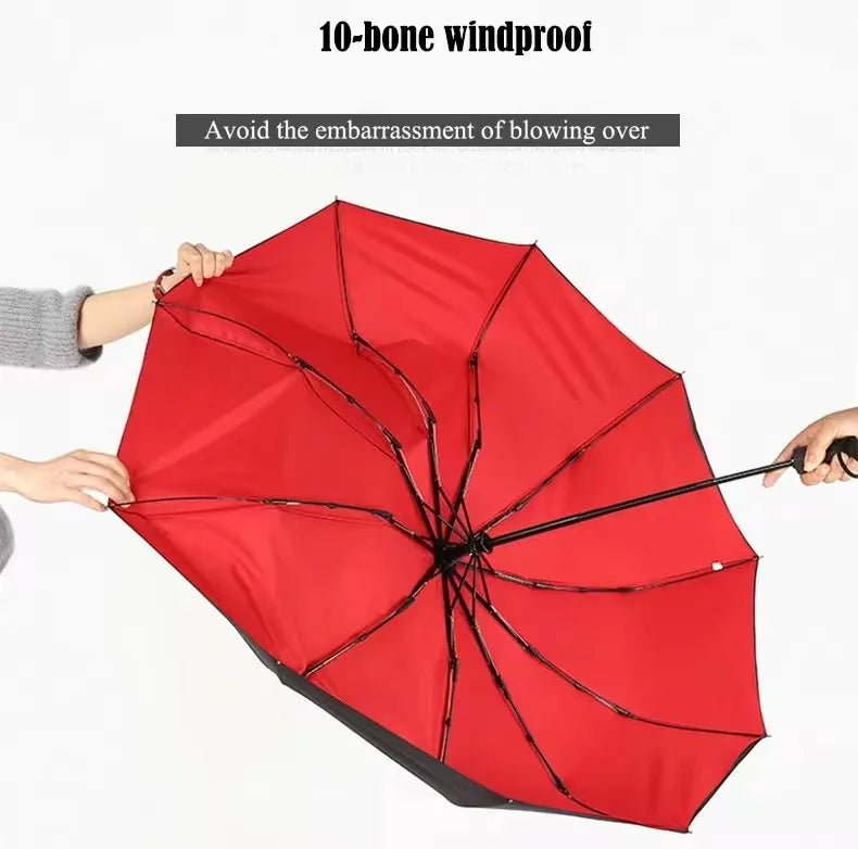 A red 10-bone windproof umbrella being held open against the wind.