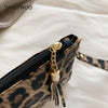 A close-up of a leopard print PU leather wrist bag with a gold chain detail.
