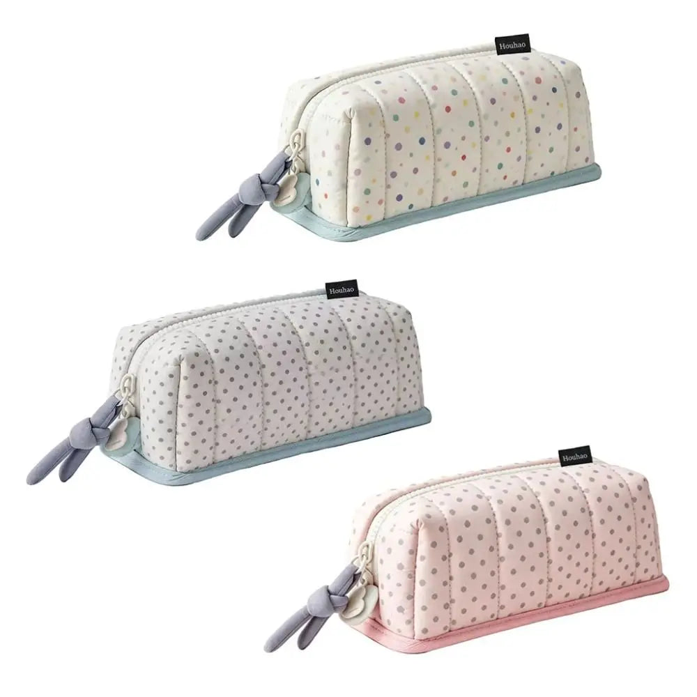 A light pink pencil case with a white dot pattern and gray fabric ties.