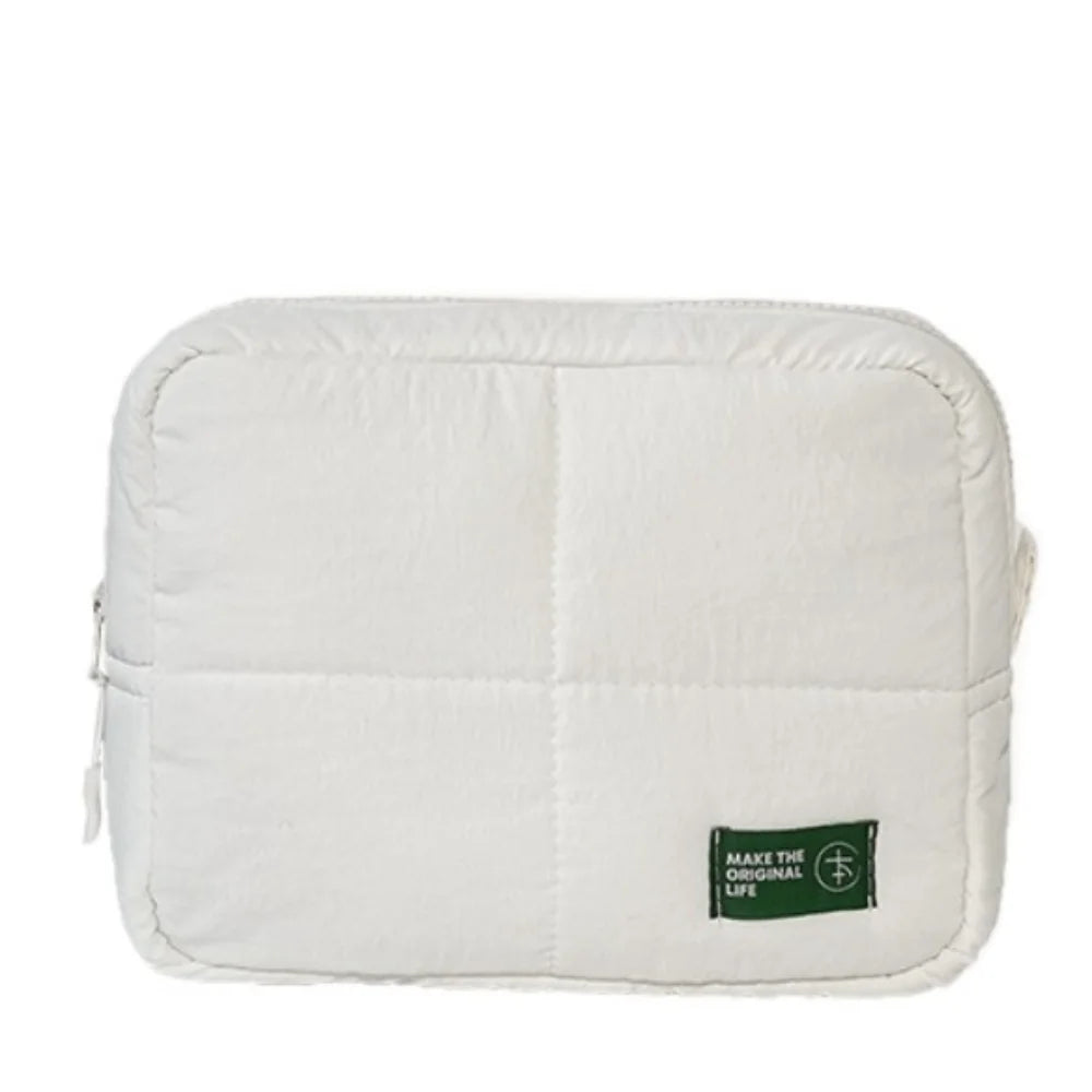 A white aesthetic quilted puffer makeup bag with a flap closure.
