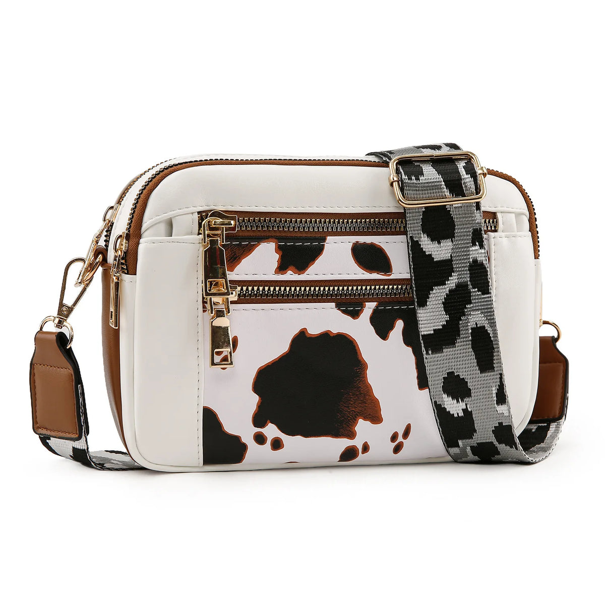 A white PU leather crossbody bag featuring a black and white cow print design and gold hardware.