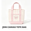 Bolso tipo tote de lona a rayas rosa y blanco con un logo circular que dice TRADER JOE'S.