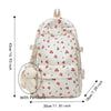 Mochila de varios bolsillos con estampado floral crema y un colgante de pompón blanco.