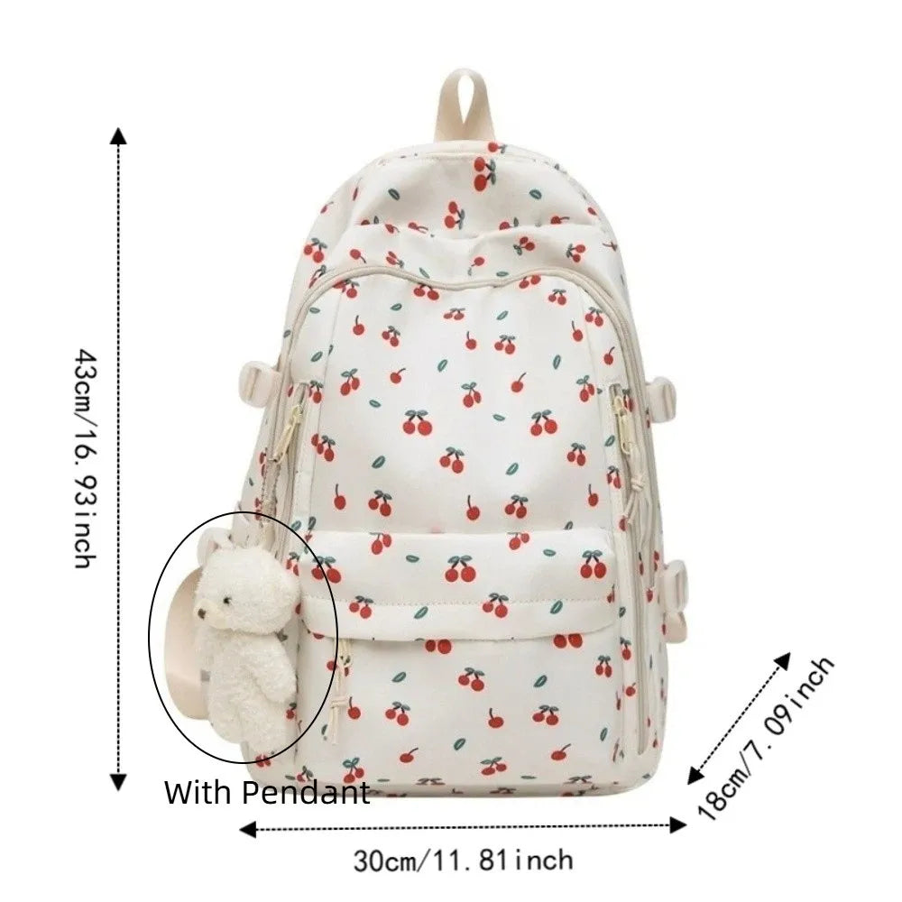 Mochila de varios bolsillos con estampado floral color crema y un colgante de pompón blanco.