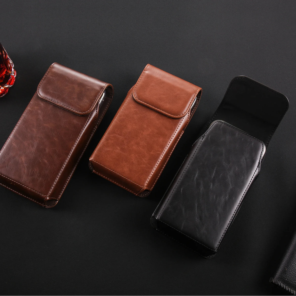 A brown leather belt loop phone case for iPhone displayed on a black background.