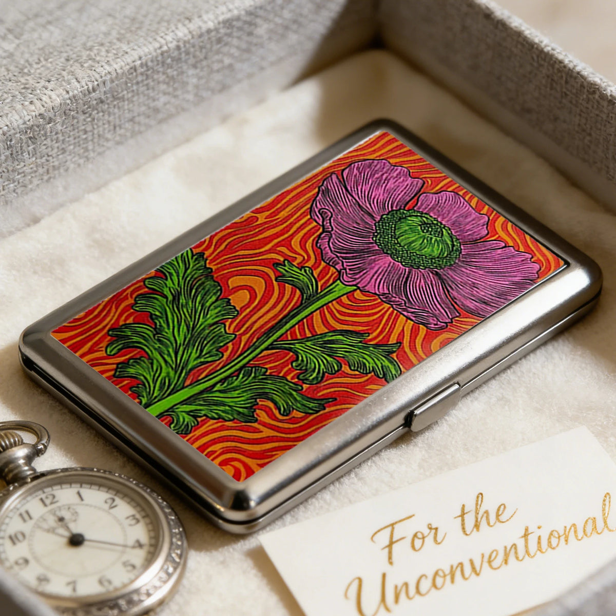 Art Deco metal card case with a floral design featuring pink and green flowers on a red background