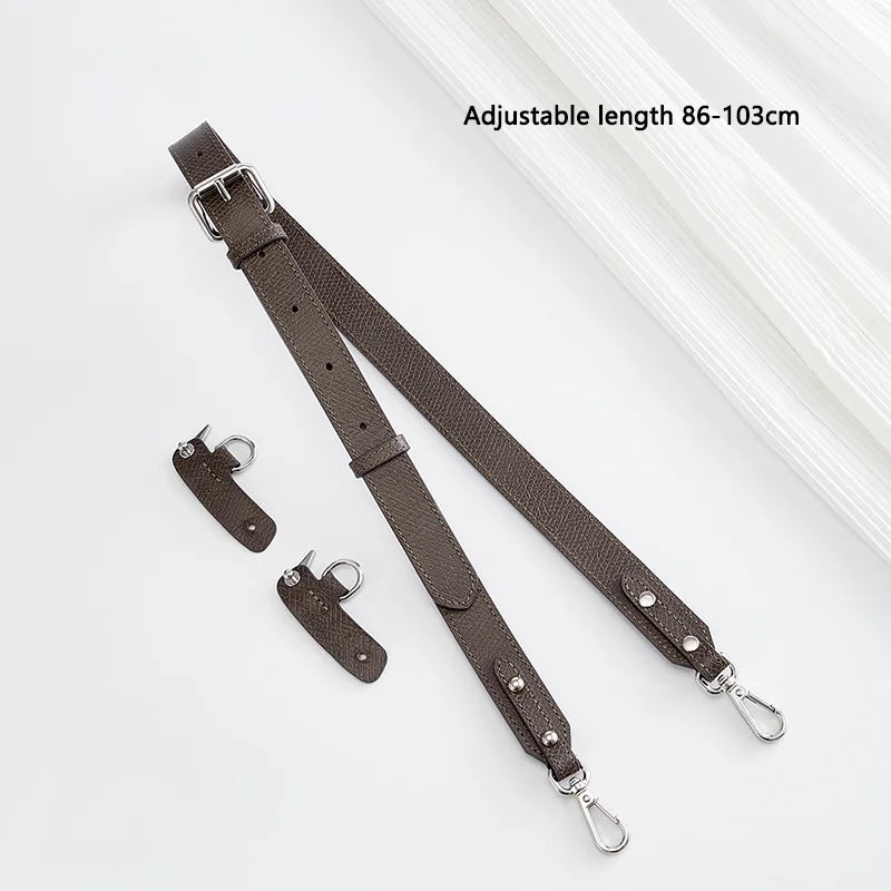A dark brown leather crossbody strap with adjustable length, shown against a white background.