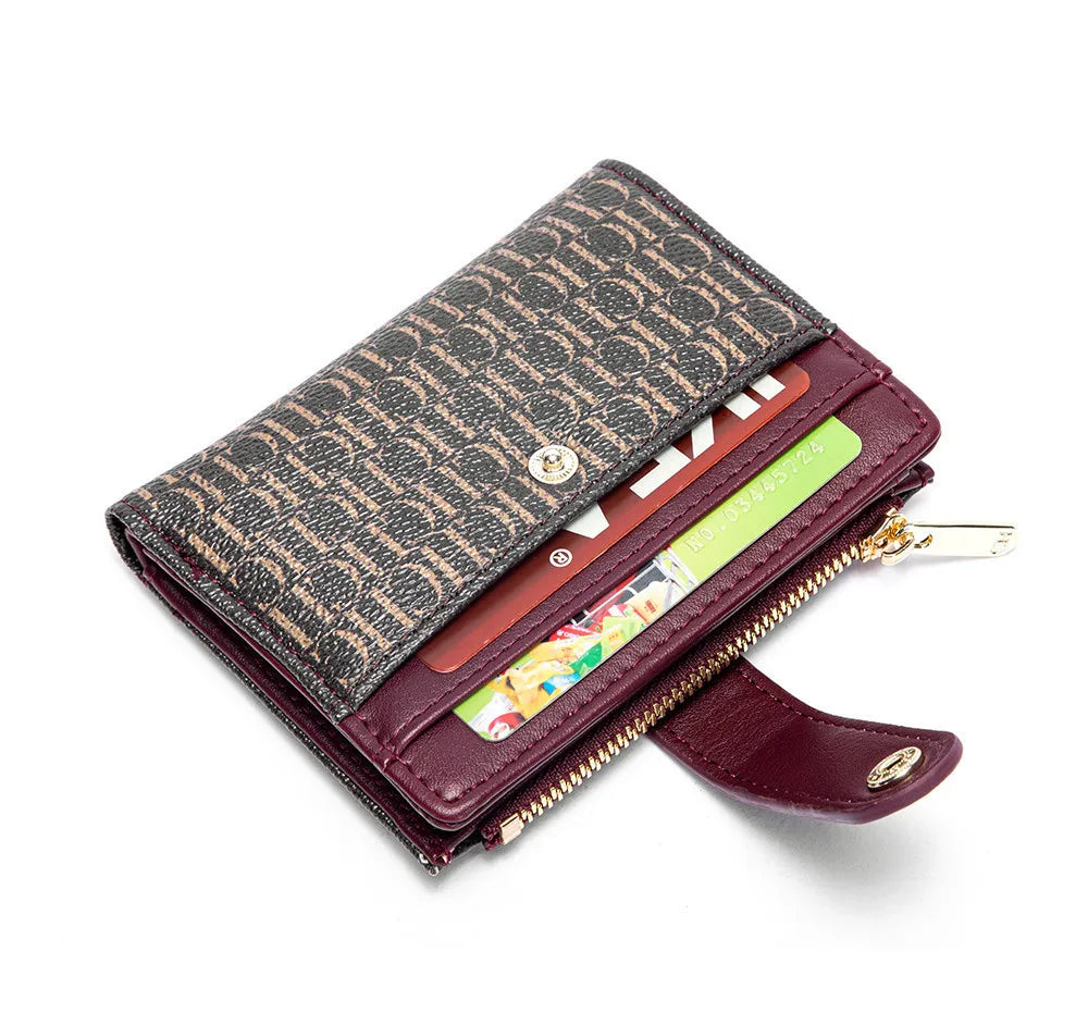 A dark brown leather folding wallet with a patterned cover and gold-toned zipper visible.