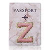 Funda de pasaporte de imitación de cuero rosa con una Z dorada y un ícono de avión.