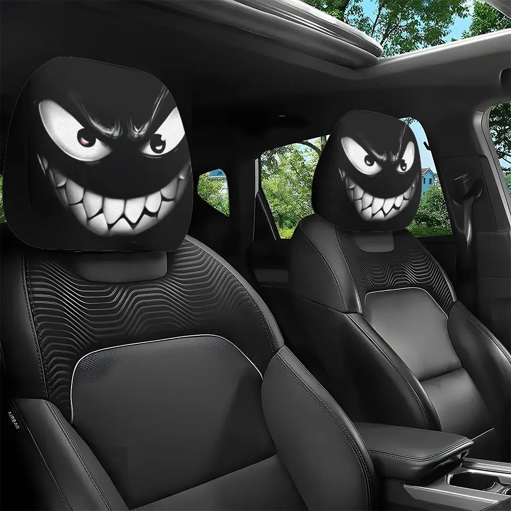 Housses décoratives noires pour tête de siège de voiture avec un visage de monstre menaçant sur le revêtement.