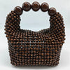 A dark brown beaded clutch bag with a rounded top and a decorative beaded texture.