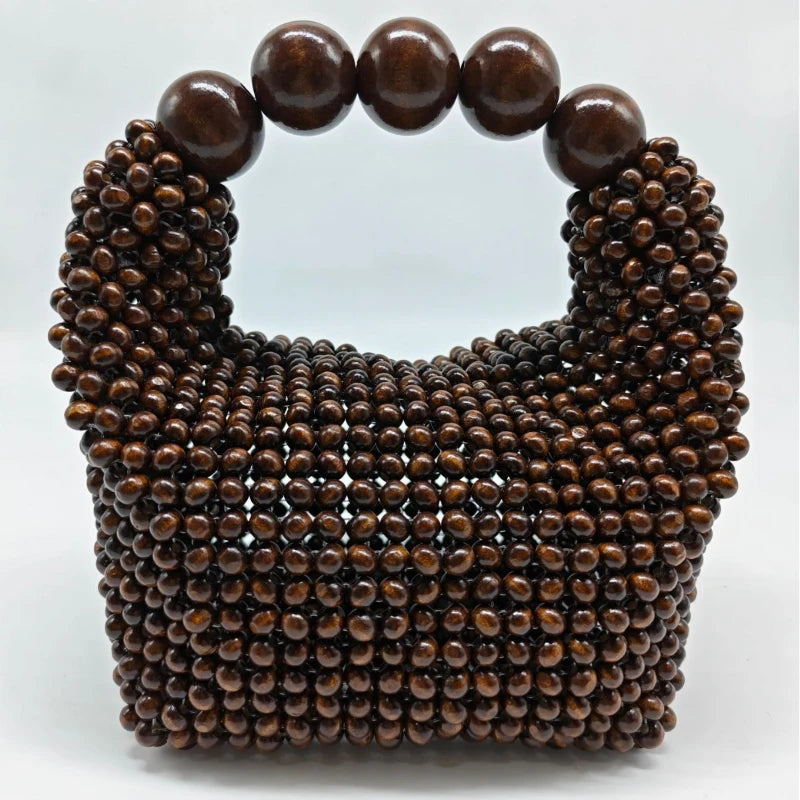 A dark brown beaded clutch bag with a rounded top and a decorative beaded texture.