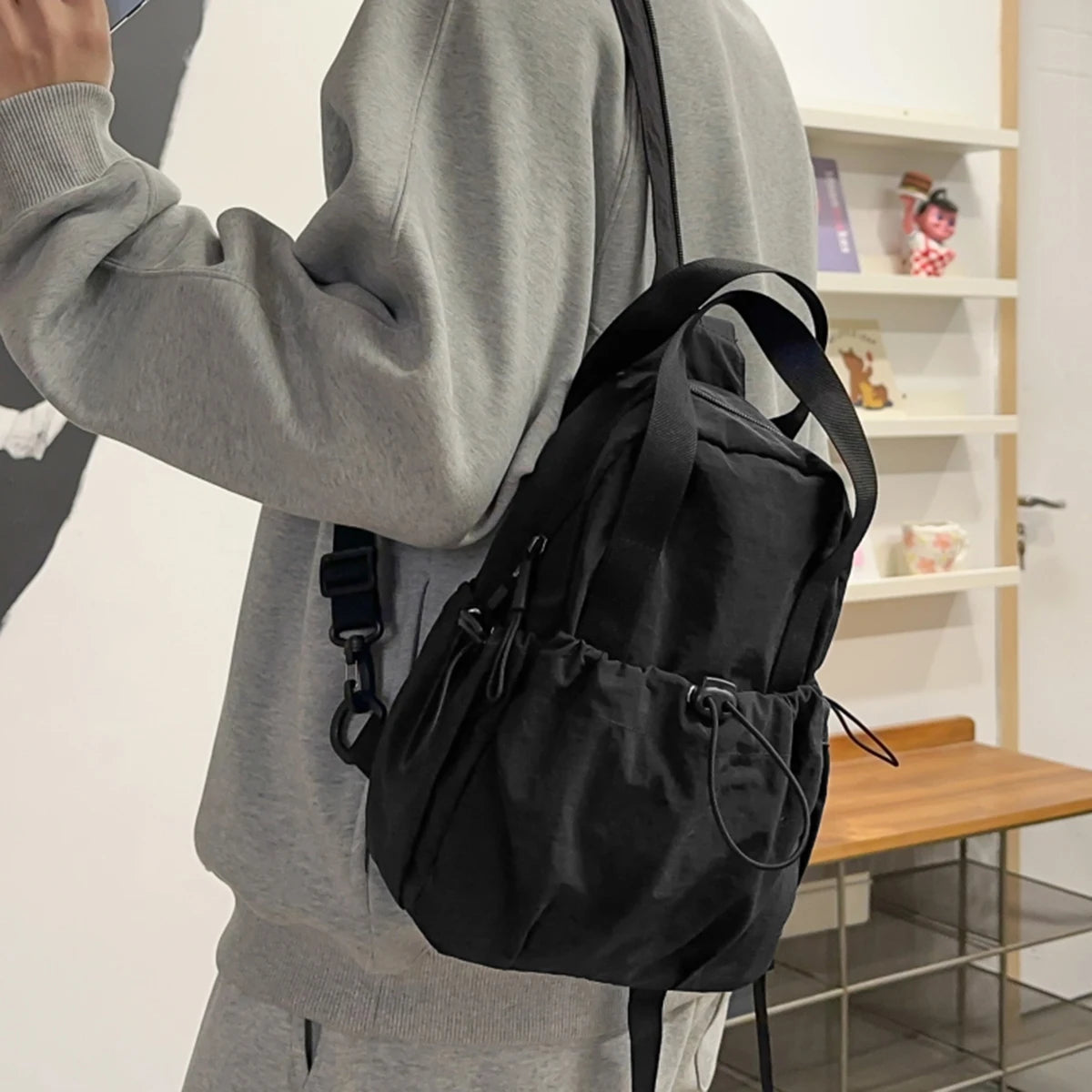 A woman is holding a black casual backpack with a laptop compartment against a white background.