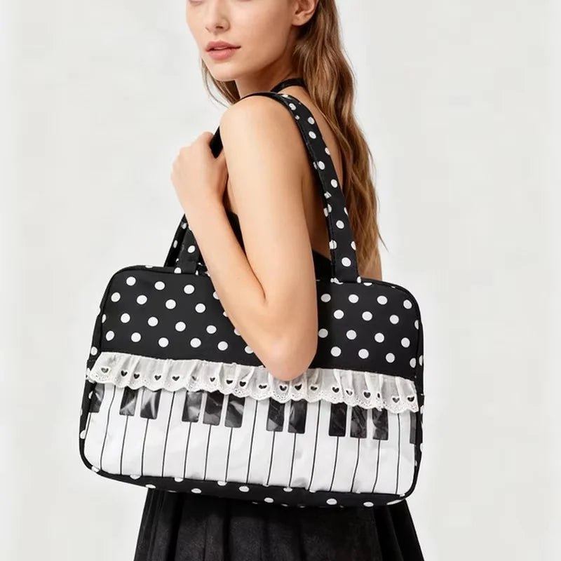 A black tote bag with white polka dots and piano lace trim is held by a woman.