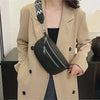 A woman wearing a beige blazer holds a black PU leather multi-pocket crossbody bag with a patterned strap.
