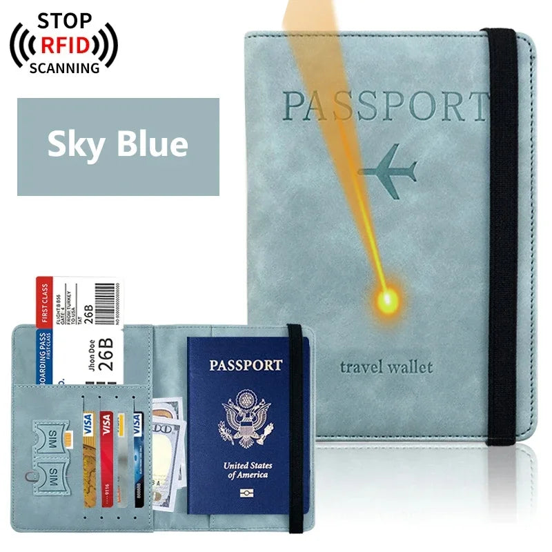 A light blue passport holder wallet with a black strap and an RFID scanning protection label.