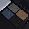 A collection of four slim leather bifold wallets in shades of gray, blue, brown, and black placed on a dark surface.