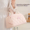 A light pink quilted insulated PU leather lunch tote bag being held by a person.