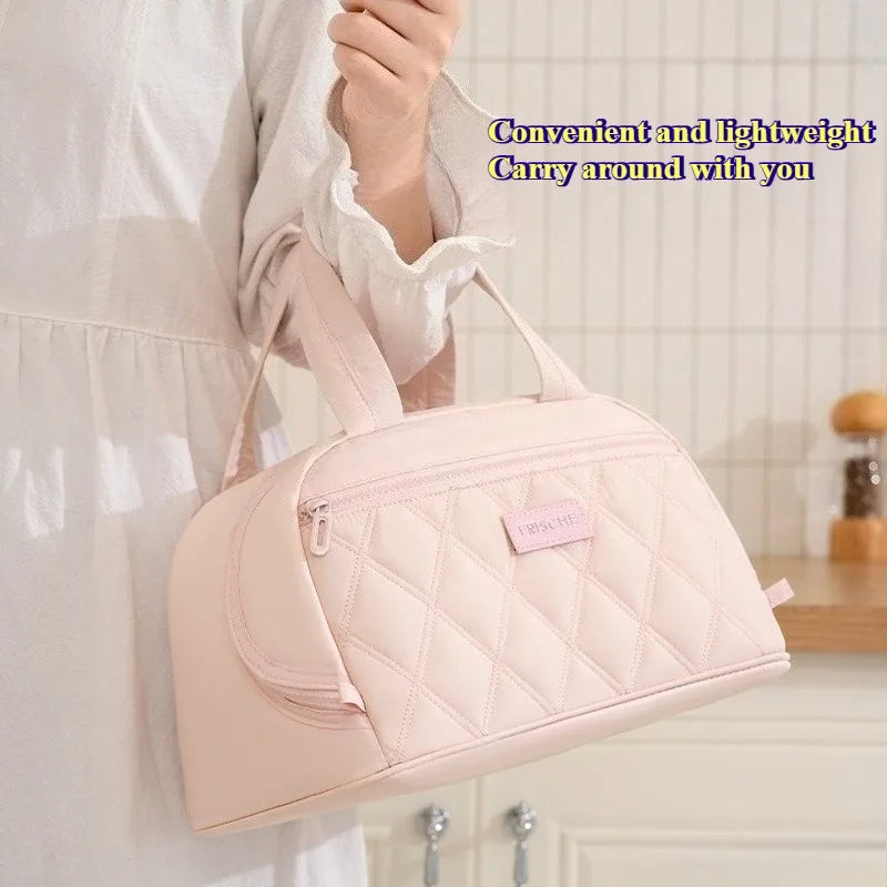 A light pink quilted insulated PU leather lunch tote bag being held by a person.
