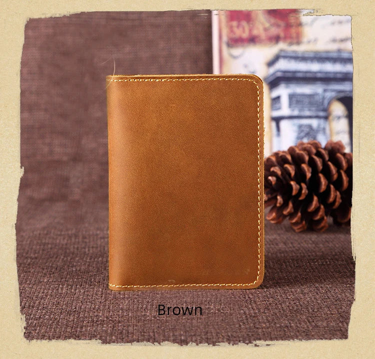 A brown genuine leather passport wallet with card holders resting on a dark brown textured surface.