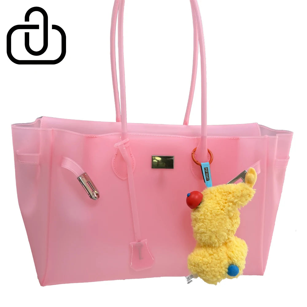 Sac en gelée transparent rose avec poignées roses et un jouet en peluche jaune à l'intérieur.