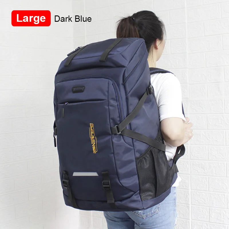 A dark blue large capacity travel backpack is shown from the back, with a white shirt visible.