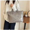 A person holds a gray transparent waterproof PVC tote bag against a light background.