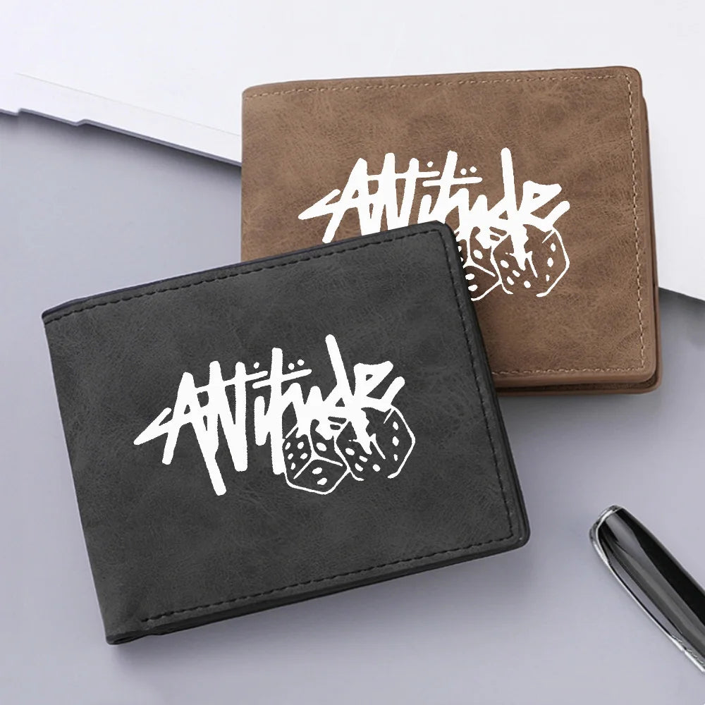 A dark gray leather wallet featuring a white stylized text and dice print, placed next to a brown leather wallet.